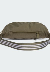 Bolsa de tela en verde oliva con una superficie texturizada, cuenta con un cierre de cremallera y una correa ajustable a rayas en verde oliva y blanco.