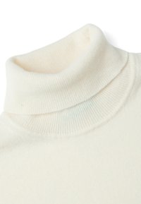 Pull en col roulé crème avec texture côtelée, tissu doux et design ajusté. Il présente un large col roulé et des coutures sans couture.