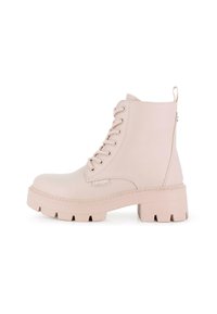 Botines beige de tobillo fabricados en material sintético suave, con punta redonda, parte delantera con cordones y suela gruesa con un tirador en la parte posterior.