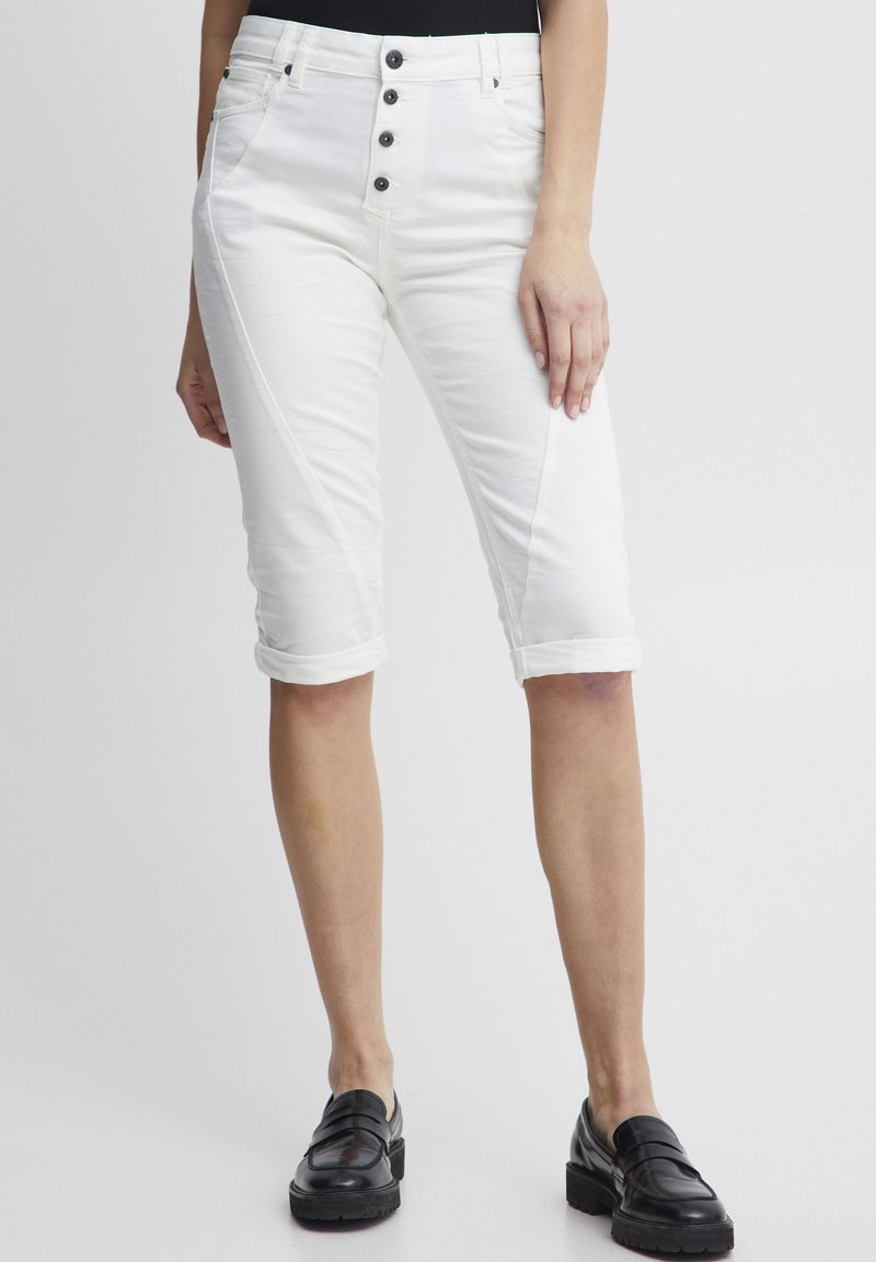 Pantalons capri blancs avec une fermeture à cinq boutons, des poignets roulés, des poches avant et une coupe slim. Tissu en coton lisse avec un léger éclat.