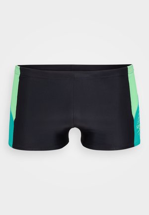 Schwarze Schwimmshorts mit türkisfarbenen und grünen Seitenpanelen, aus dehnbarem Material gefertigt, mit einem Logo auf der rechten Seite. Glatte Textur.