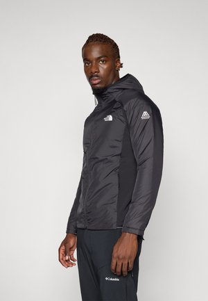 Veste noire à capuche avec fermeture éclair à l'avant, poignets élastiques et poches latérales. Présente des accents de logo sur la poitrine et la manche. Matière lisse et légère.