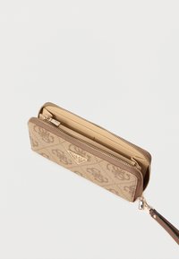 Béžová peňaženka s reliéfnym vzorom loga, zlatým kovaním, zapínaním na zips a svetlohnedým vnútrom. Má remienok na zápästie. Kompaktný obdĺ�žnikový tvar.