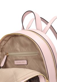 Zaino in ecopelle rosa con cerniere dorate, tasca interna con zip e fodera beige con un motivo logo delicato. Due spallacci regolabili.