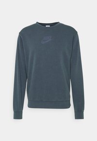 Mörkgrön sweatshirt med rundad halsringning, långa ärmar, ribbade muddärmar och en texturerad Nike-logga i en mörkare nyans på framsidan.