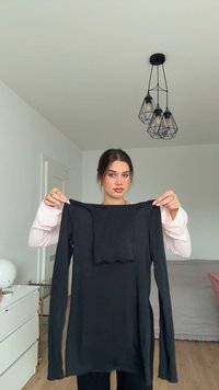 Zwarte lange mouwen top met een ronde halslijn en een gestructureerd rechthoekig accent op de borst, gemaakt van zacht materiaal.