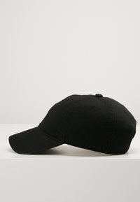 Gorra de béisbol negra hecha de algodón. Presenta un visera curva, diseño de seis paneles y un botón en la parte superior. Textura suave sin logotipos visibles.