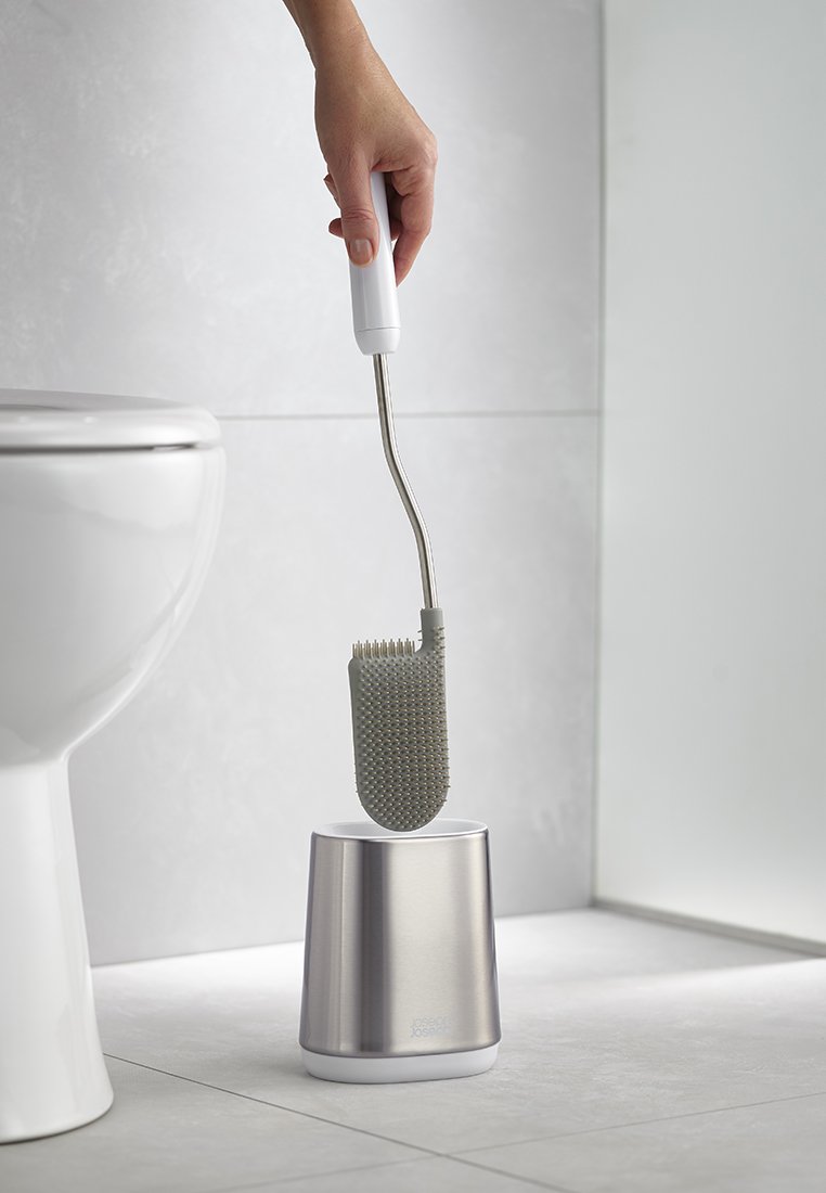 Toilettenbürste mit einem strukturierten grauen Silikonkopf und einem Halter aus rostfreiem Edelstahl. Der Griff ist weiß und hat ein gebogenes Design für eine einfache Handhabung.