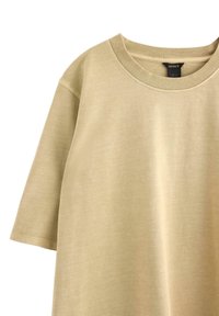 Beige bomulds t-shirt med rund hals og korte ærmer. Glat tekstur med en afslappet pasform. Ingen synlige mønstre eller accenter.