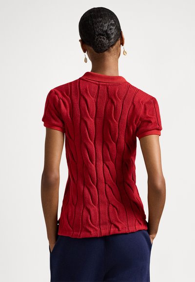 Rdeča pletena polo majica s kabelskim vzorcem, kratkimi rokavi in ovratnikom. Tkanina z teksturo in oprijetim krojem.