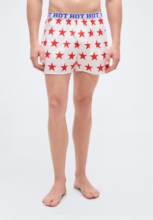 Biele boxerky s motívom červených hviezd a modrým pásom s nápisom „HOT HOT HOT“. Ľahký, priedušný materiál.