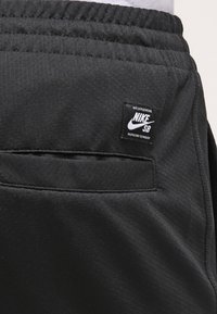 Černé sportovní šortky vyrobené z hladkého materiálu s elastickým pasem. Obsahují zadní kapsu a malou nášivku Nike SB.