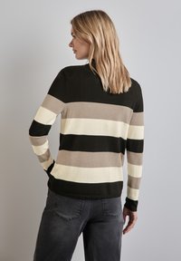 Gestreifter Pullover in Schwarz, Creme und Taupe, mit Rundhalsausschnitt und langen Ärmeln. Texturiertes Strickgewebe mit taillierter Silhouette.