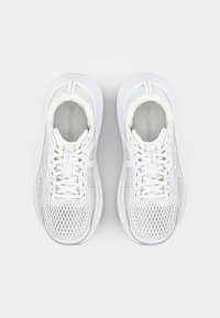 Baskets de sport blanches avec un dessus en mesh, bout rond et col rembourré. Elles sont dotées de lacets, d'un logo sur la languette et d'une semelle texturée.