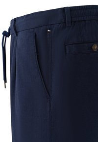 Navy blue pants made of lightweight fabric, featuring an elastic waistband with drawstring, side pockets, and one back pocket with a button.