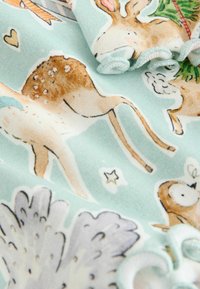 Cotton fabric featuring a light blue background with whimsical animal illustrations, including deer and bunnies, in soft, muted colors.