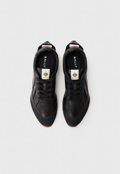 Sneaker nere in pelle con lati texture, suole in gomma e lacci neri. Presenta un'etichetta con logo sulla linguetta e un tassello alla caviglia rinforzato.