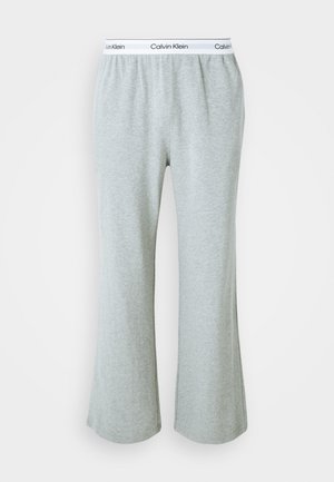 Graue, ausgestellte Sweatpants aus weichem Baumwoll-Mix, mit einem elastischen Bund und einem weißen Calvin Klein-Logo. Durchgehend glatte Textur.