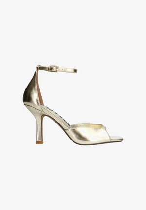 Sandale à talon haut en métal doré avec bout ouvert, bride de cheville et texture lisse. Présente un talon fin et une semelle intérieure rembourrée.