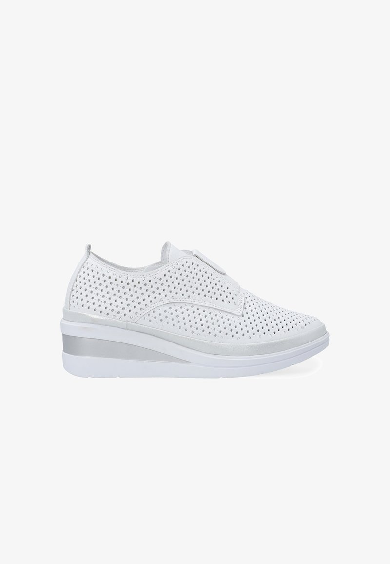 Białe perforowane sneakersy o smukłym designie, z podeszwą na koturnie i gładkim srebrnym akcentem na pięcie. Zapięcie na rzepy na górze.