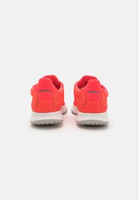 Bright pink athletic shoes with mesh upper, cushioned white sole, and reflective accents. Features a comfortable heel tab for easy wear.