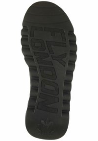 Suela de zapato de goma negra con texturas en forma de surcos y lettering en relieve "FLY LONDON". Presenta un talón más ancho y un diseño contorneado para mayor soporte.