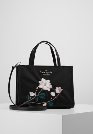 Czarna torebka Kate Spade z górnymi uchwytami, paskiem na ramię i różowo-białym kwiatowym haftem na przednim panelu.