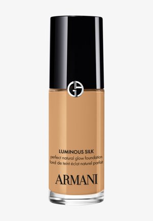 Flacon de fond de teint liquide Luminous Silk d’Armani avec bouchon noir et fond de teint beige à l’intérieur, étiqueté pour un fini éclat naturel.