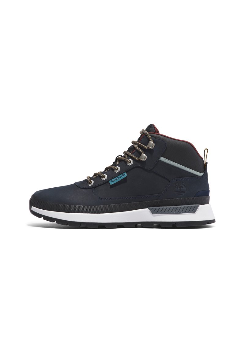 Botas medio altas impermeables de color navy con detalles en gris, ojales de metal, un sistema de cordones resistente y suela de goma negra texturizada. Logo de la marca en el lateral.