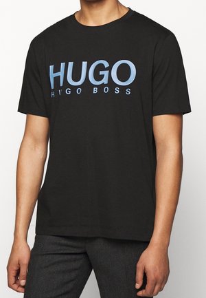 Zwarte katoenen T-shirt met een groot blauw "HUGO" logo en "HUGO BOSS" eronder in kleinere tekst. Standaard ronde hals en korte mouwen.