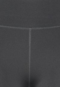 Mörkgrå leggings i ett stretchigt, slätt material. Har platta sömmar och en hög midja för komfort och passform.