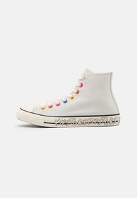 Sneakers alte bianche con occhielli colorati, materiale in tela, suola in gomma e "MYSTORYMYSTORY" stampato sul lato.