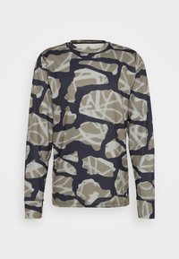 Camisa de manga longa com padrão de camuflagem em azul escuro, bege e branco, com decote redondo e tecido texturizado.