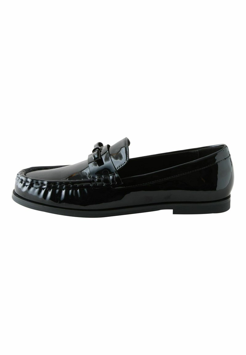 Svart lackläder loafer med en slät yta, mockasinstygn och en dekorativ rosett på framfoten. Platt gummisula.