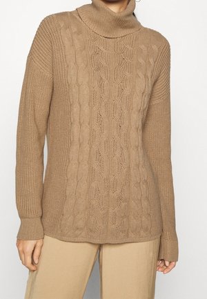 Suéter de punto beige con cuello alto doblado, que presenta un patrón de trenzas texturizadas en el centro y puños acanalados. Material suave y liso.