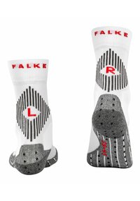 Calze alla caviglia bianche con il marchio "FALKE" in rosso, motivo a rombi in nero e suole texturate grigie con grip per una migliore aderenza.