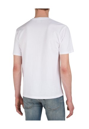 Camiseta de algodón blanca con mangas cortas, cuello redondo y dobladillo recto, combinada con vaqueros de color azul claro con un lavado desvaído y costuras sutiles.