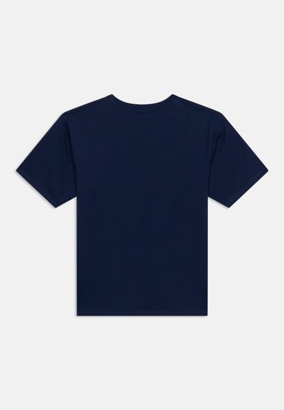 Απλό μπλε σκούρο κοντομάνικο T-shirt, απλωμένο επίπεδα που δείχνει την πίσω πλευρά, πάνω σε φωτεινό φόντο.