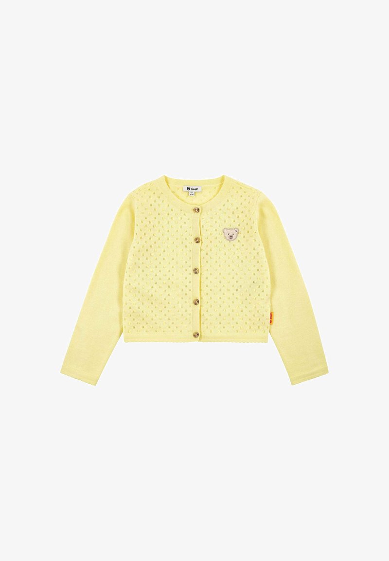 Cardigan tricoté jaune à manches longues, col rond, fermeture à boutons et écusson en forme d'ours en peluche sur la poitrine gauche. Motif texturé sur toute la surface.