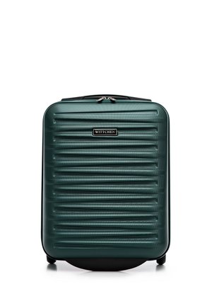 Green hardshell suitcase with horizontal ridges, a black logo plate, and dual zippers. Features four wheels for mobility and sturdy handles.