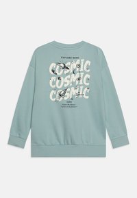 Sudadera azul claro hecha de una tela suave, con un atrevido estampado gráfico en la parte posterior que presenta la palabra "COSMIC" repetida y ilustraciones con temática espacial.