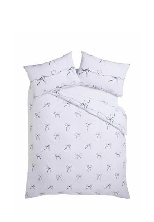 Weißes Bettwäsche-Set mit schwarzen Schleifen- und Herzlinienzeichnungen auf dem Bettbezug und passenden Kissenbezügen auf einem Bett.