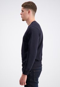 Felpa blu navy in cotone, con collo a giro, polsini e orlo a costine, dettagli sui fianchi e vestibilità rilassata.