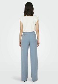 Pantalons �à jambes larges bleu clair avec un design ajusté, dotés de deux poches arrière et de détails en boutons. Texture de tissu douce et lisse.