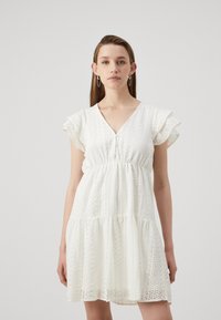 White dress with short, ruffled sleeves, a V-neckline, and a gathered waist. Features intricate lace detailing and a tiered skirt design.