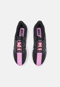 Scarpe da corsa nere con tomaia in mesh, dettagli rosa e viola, lacci neri e suola bianca. Logo Nike ben visibile sulla linguetta.