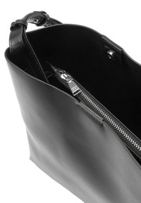 Czarna skórzana torba o gładkiej fakturze, wyposażona w zapinaną na zamek kieszeń wewnętrzną i minimalistyczny design. Pasek wykonany z dopasowanej skóry.