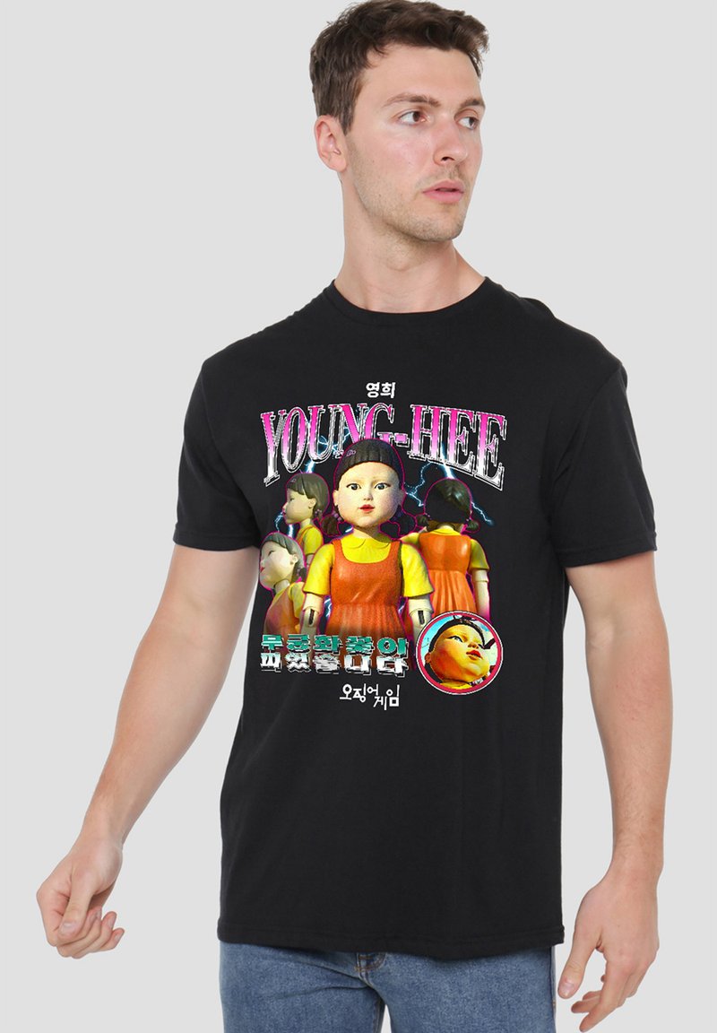 Black cotton T-shirt featuring a graphic print of a doll with a yellow and orange outfit, and the text “YOUNG-HEE” in vibrant colors.