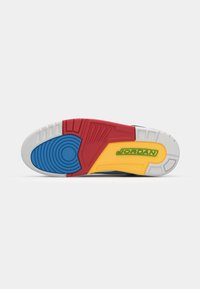 Air Jordan sneakersål med multicolor sektioner: blå, rød, gul og hvid. Tekstureret gummidesign med cirkulære og lineære mønstre.