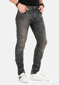 Grijze slim-fit jeans van denim, met een vervaagde wassing, standaardzakken en een strak ontwerp. Gecombineerd met witte sneakers.